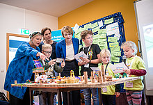 Heike Kahl, Geschäftsführerin DKJS, Annett Hofmann, Frau an der Seite des sächsischen Ministerpräsidenten Kretschmer, und Elke Büdenbender, DKJS-Schirmherrin, schauen sich Modell zur Schulhofneugestaltung an