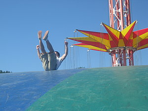 Ein junge rutscht ein großes Luftkissen herunter.