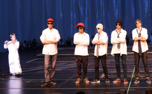 Fünf Jungs stehen mit verschränkten Armen auf einer Bühne
