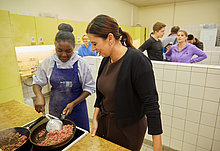 Senatorin Sandra Scheeres im Gespräch mit einer Teilnehmerin der Berliner Ferienschule, angeboten von Jugendsteg e.V., in der Lerngruppe „Kochen“.