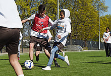 zwei Mädchen kämpfen auf dem Fußballplatz um den Ball
