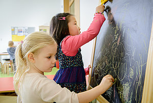 Zwei Mädchen schreiben an die Tafel