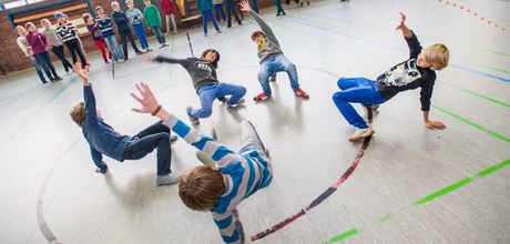Kinder tanzen in einer Turnhalle